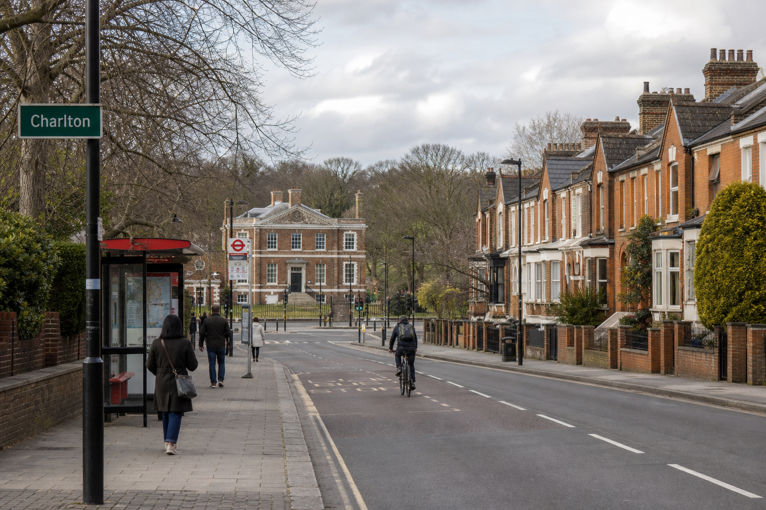 A quiet street in Fulham with red brick terraced houses and a cyclist, leading to a grand building in the distance.