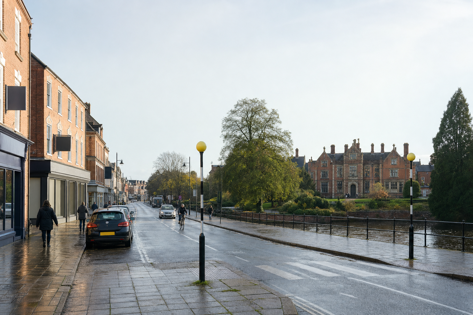 A quiet street lined with buildings and a large historic mansion in the background on a cloudy day.
