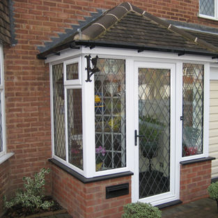 Enclosed brick porch with a tiled roof and latticed leaded glass windows