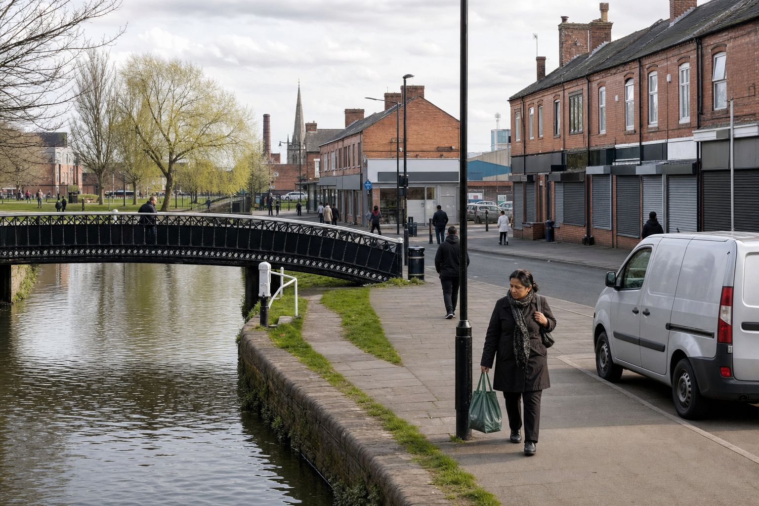 A woman walks along a canal path beside a bridge and terraced buildings under a cloudy sky.