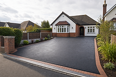 Bungalow with a freshly paved driveway and landscaped front garden under a cloudy sky.