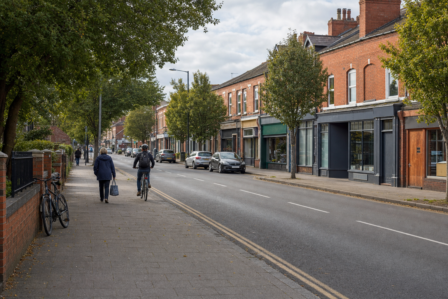 A cyclist and a pedestrian are on a tree-lined street with parked cars and brick buildings.