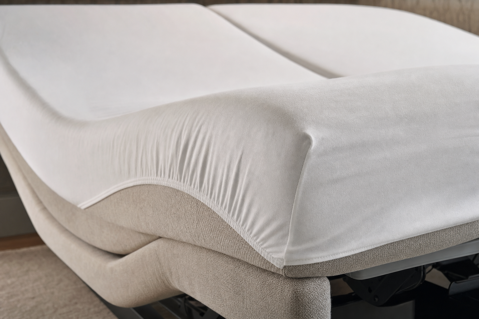 Adjustable bed with a fitted white sheet in a partially raised position.