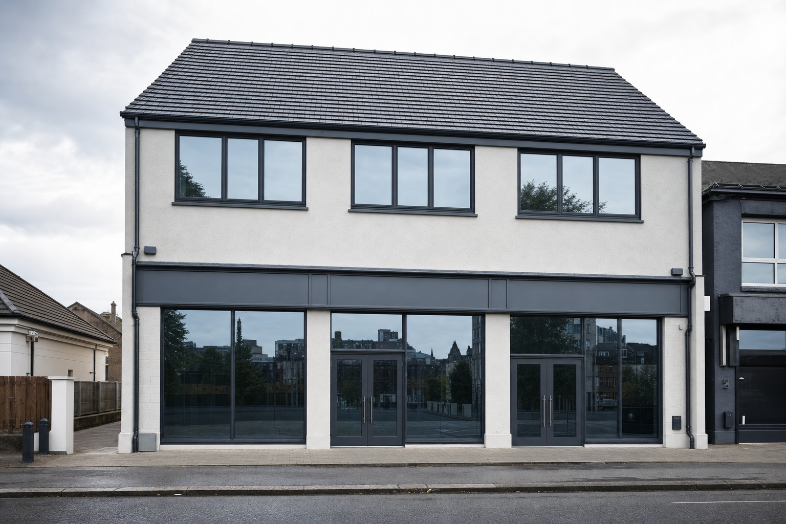 A modern two-storey commercial building with large windows and a grey roof.