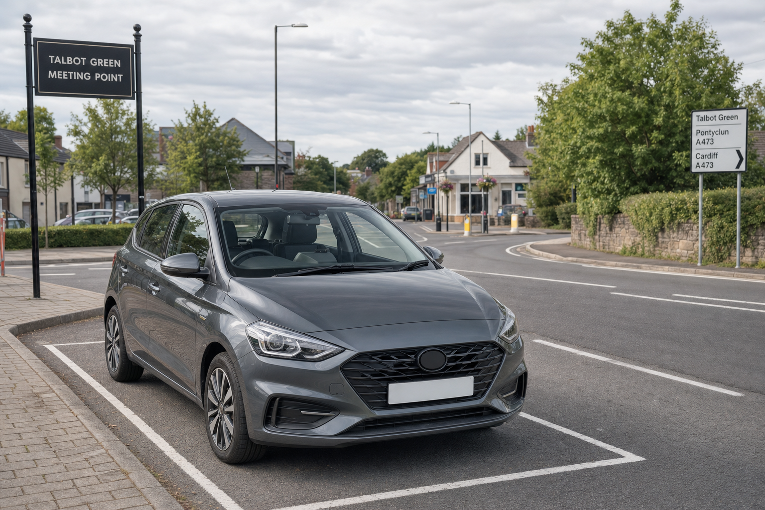 A parked grey car at Talbot Green Meeting Point with road signs visible.