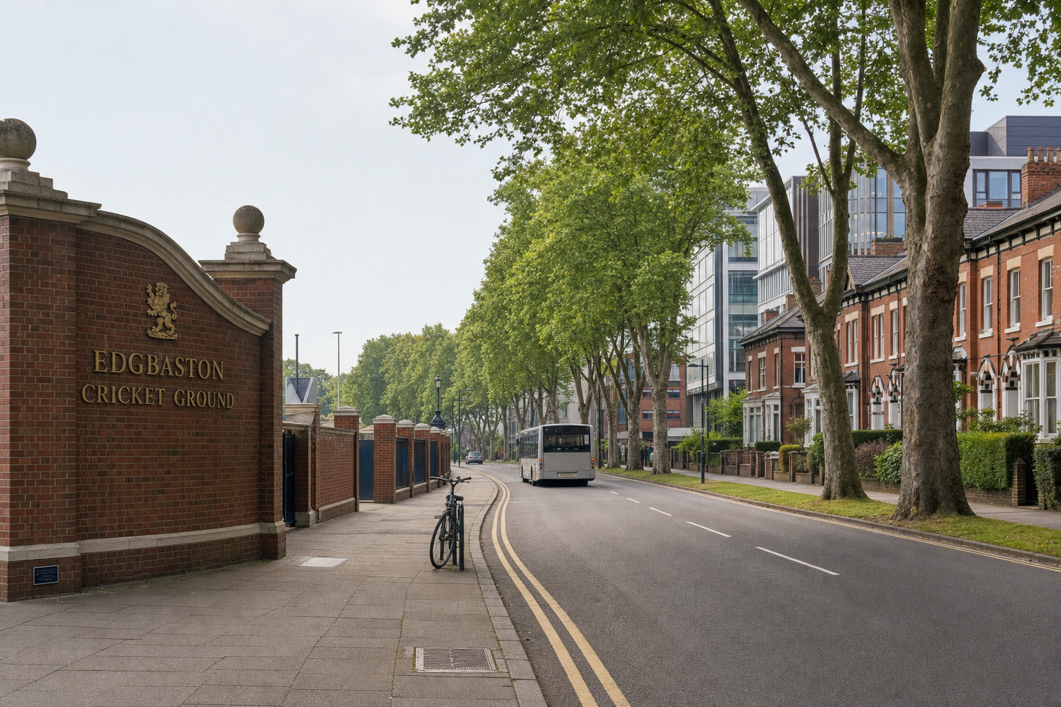 Edgbaston Cricket Ground entrance with a bicycle on the pavement and a bus driving along a tree-lined street.