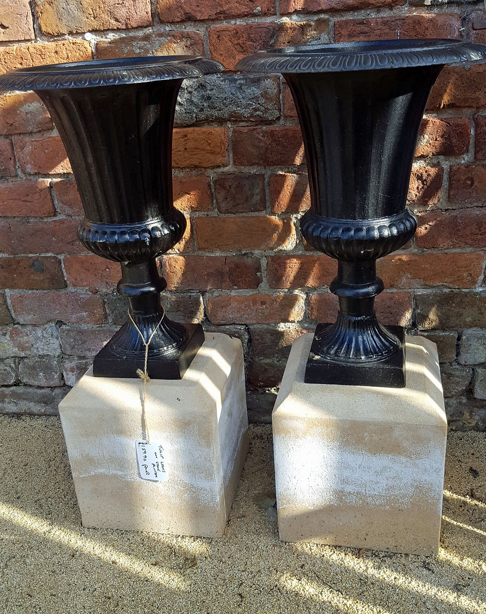 Two cast iron urns on stone plinths 3159.90p