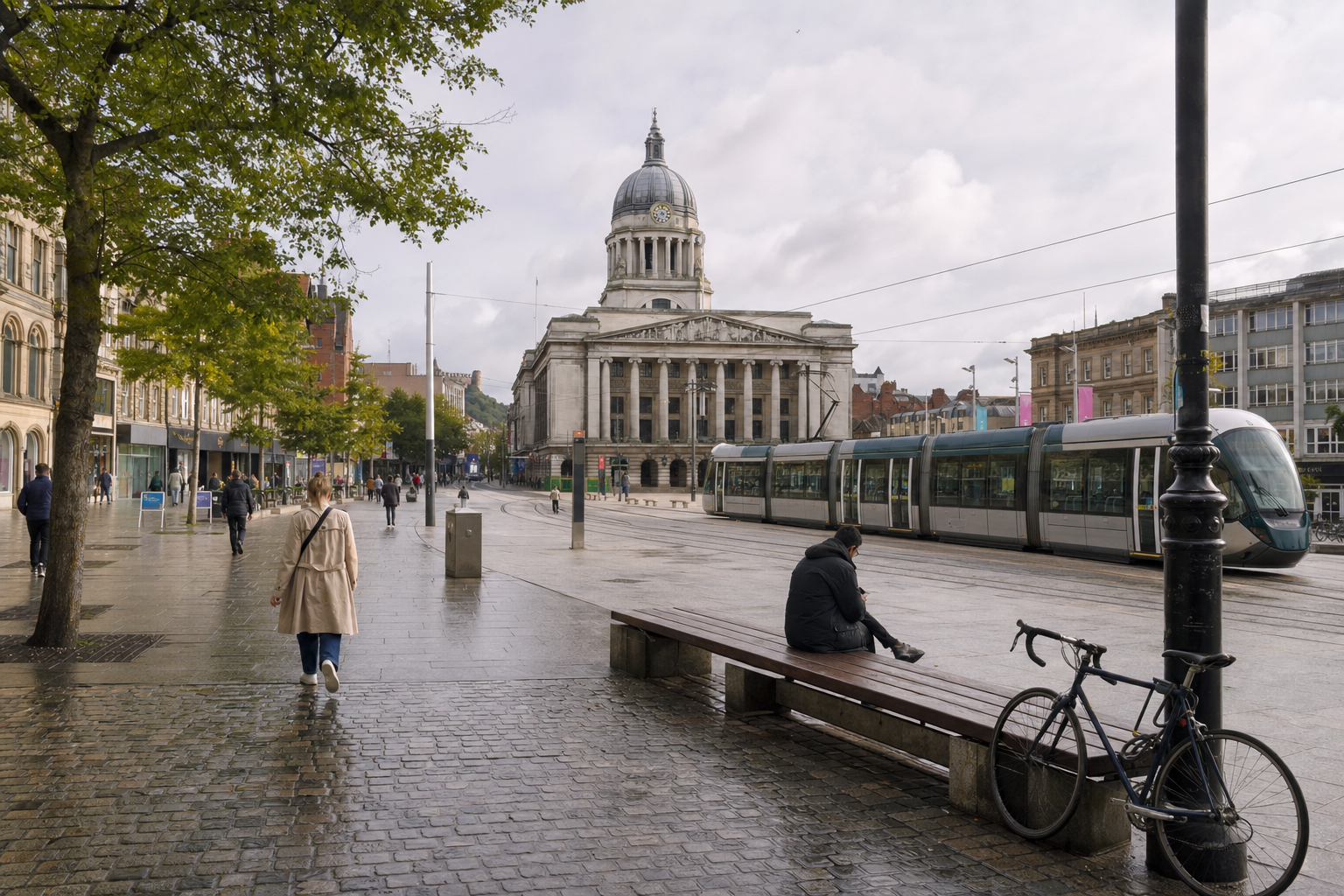 Tram and pedestrians in front of a grand historic building with a clock tower on a rainy day.