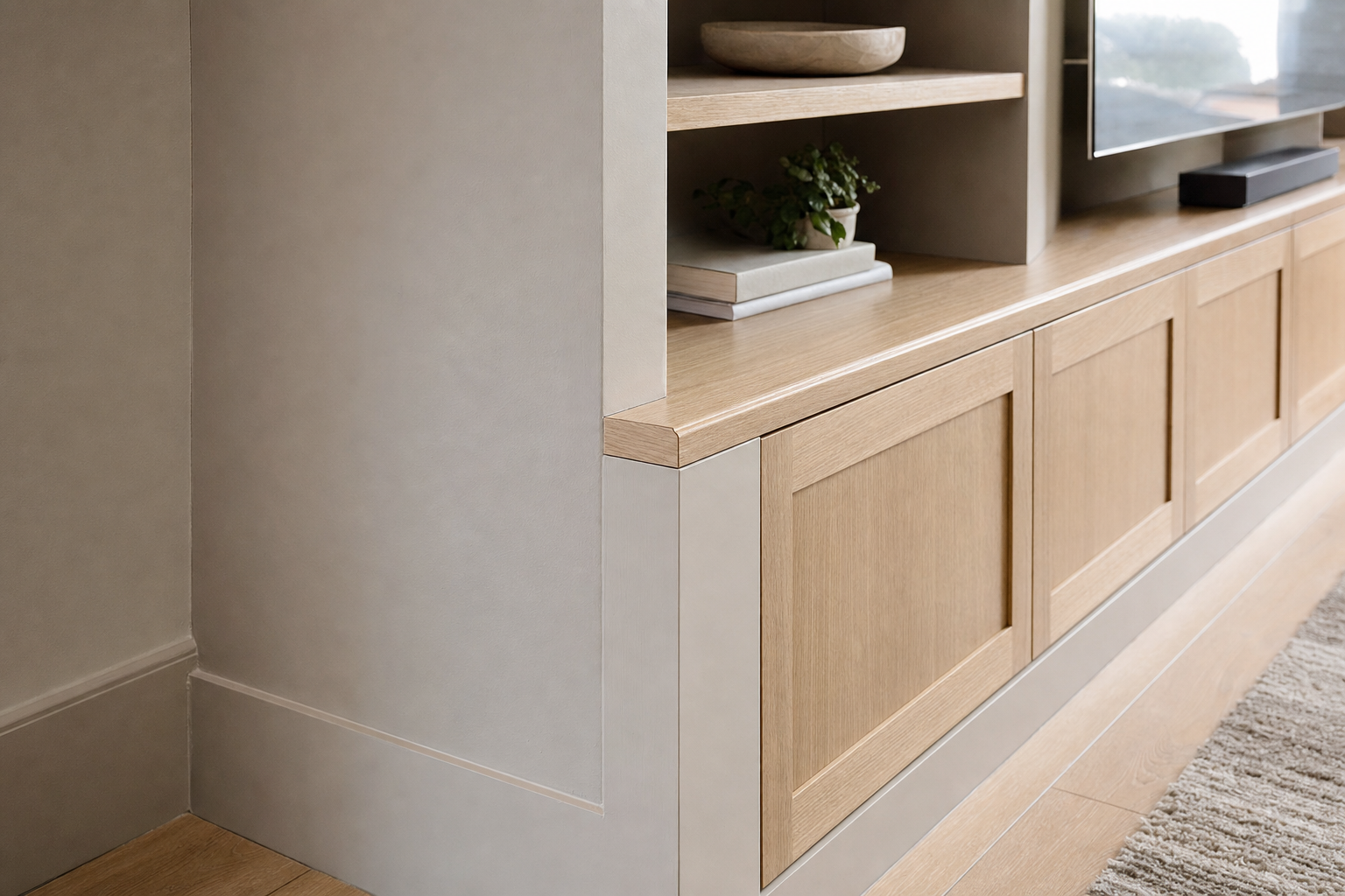 Bespoke oak living room media unit featuring built-in lower cabinets and open display shelving.