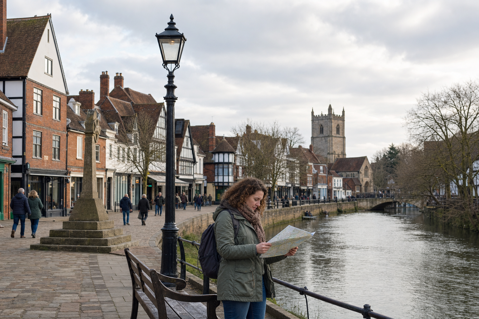 Woman reading a map along a riverside walkway in a historic town with a church tower in the background.