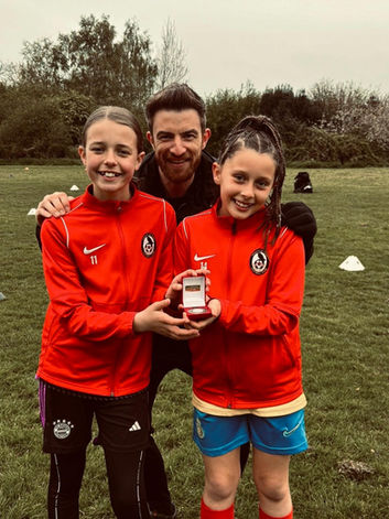 Coach with two young female footballers