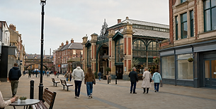 People walking on a pedestrian street lined with historic buildings and a clock-topped market hall in the background.
