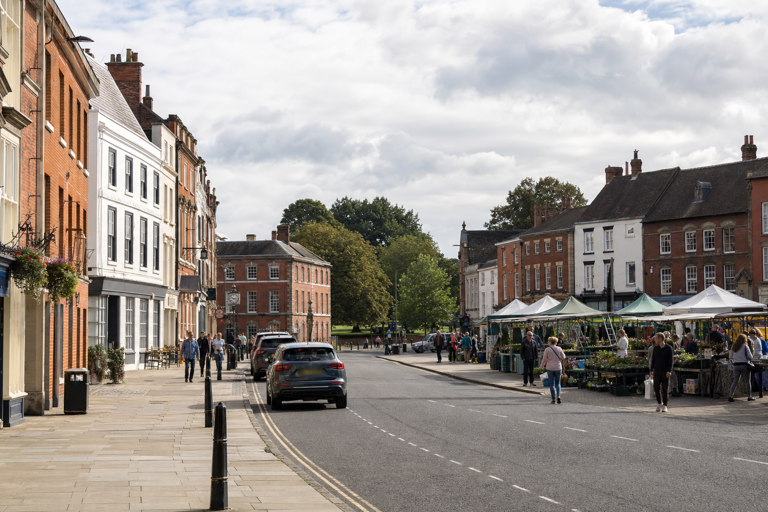A bustling street scene with people visiting a market and walking past historic buildings.