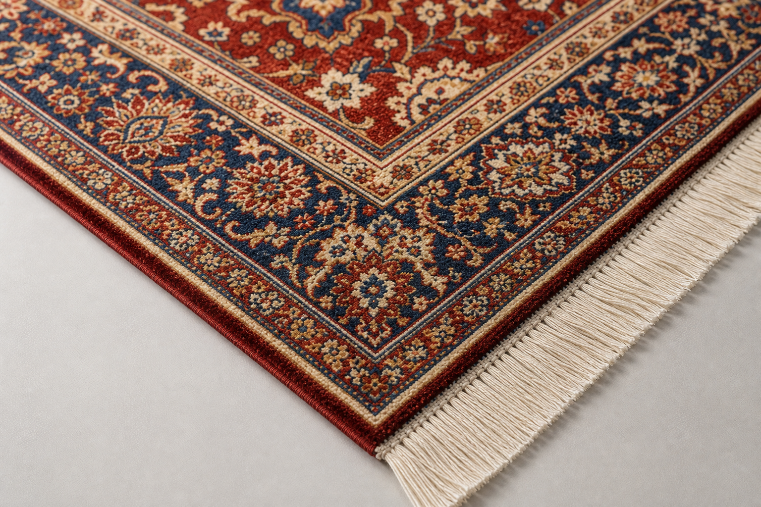 Colourful Persian carpet corner with intricate floral patterns and cream fringes on a light grey floor.