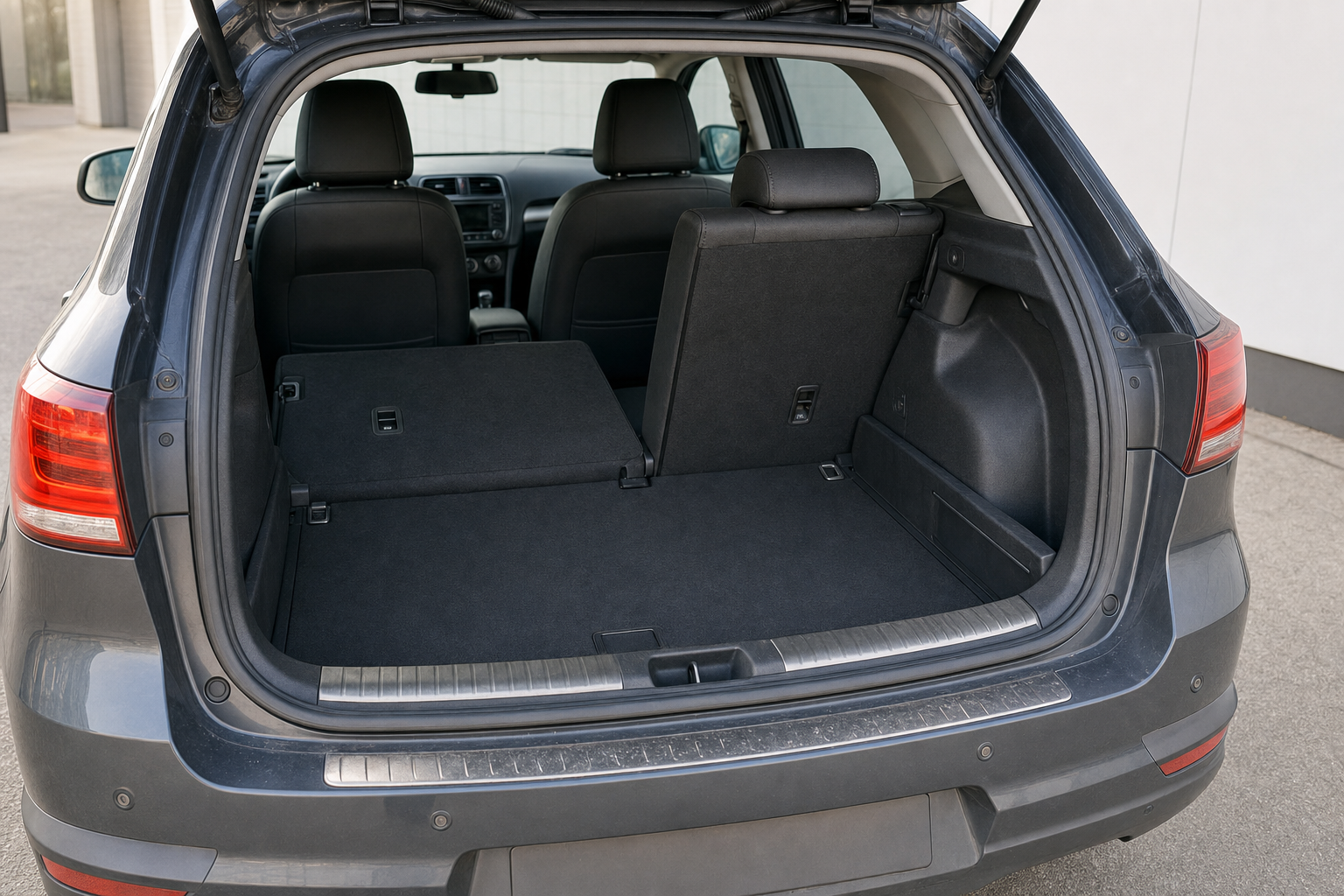 Open boot of a grey SUV with one rear seat folded down for extra cargo space.