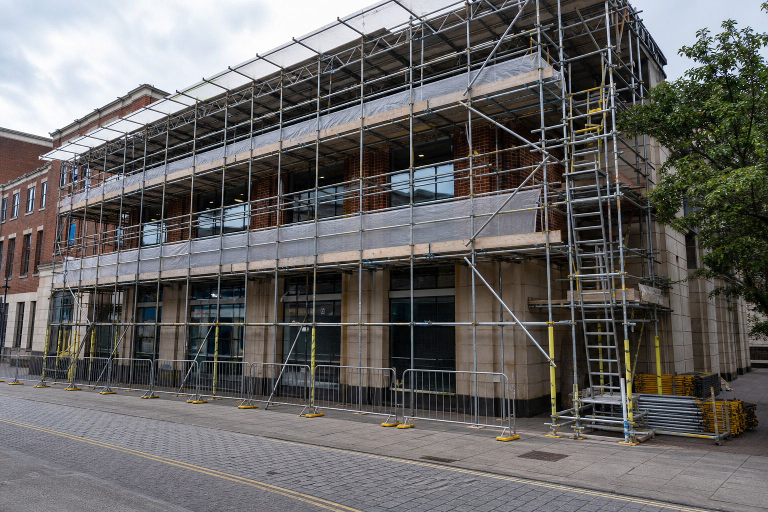 Scaffolding covers a two-story brick building under renovation on an empty street.