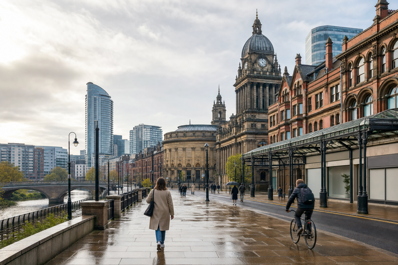 People walking and cycling on a wet city street, flanked by historic and modern buildings under a cloudy sky.