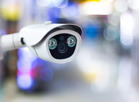 Modern CCTV camera on a wall.Concept of surveillance and monitoring. Toned image double exposure mock up