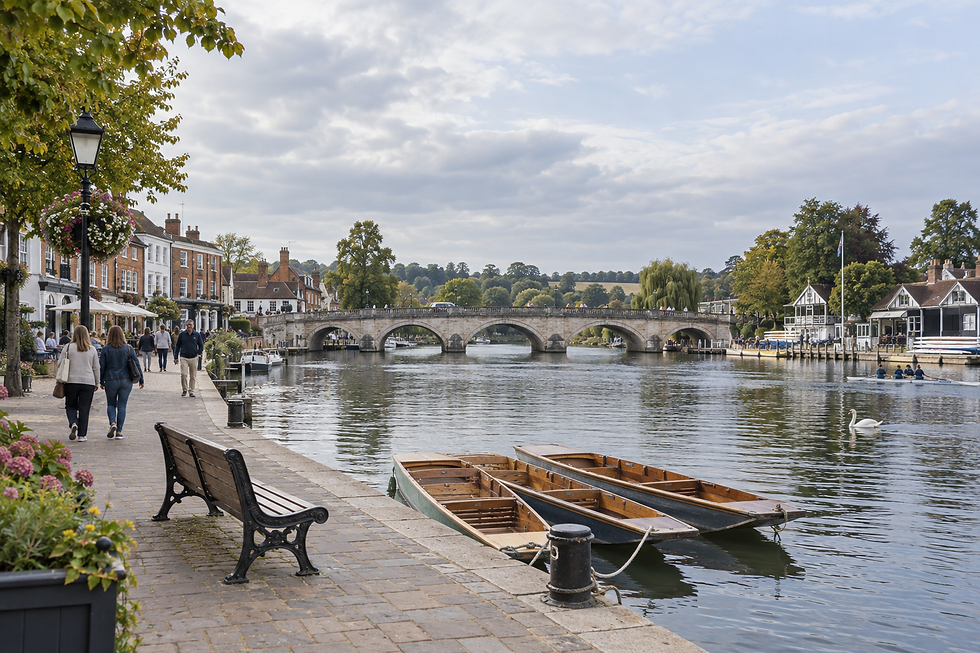 A scenic riverside view with a stone bridge, rowing boats, and people walking along the path in a quaint town setting.