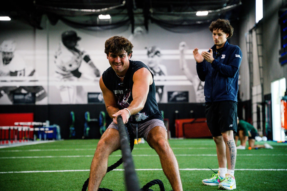 Male athlete pulling a rope being supervised by a Barwis Personal Trainer