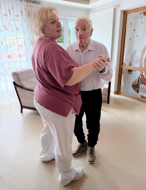 Ein Senior tanzt gemeinsam mit einer Pflegekraft im AWO Seniorenzentrum Wohnen im Alter in Sonneberg und genießt einen fröhlichen Moment.