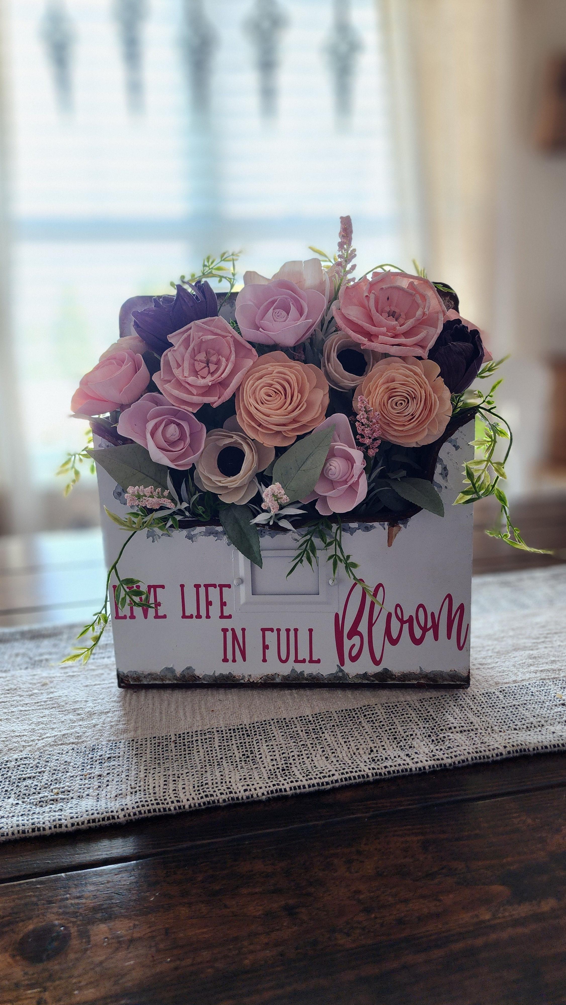 Custom sola flower arrangement featuring a metal mailbox container with vinyl lettering reading "Live Life in Full Bloom".