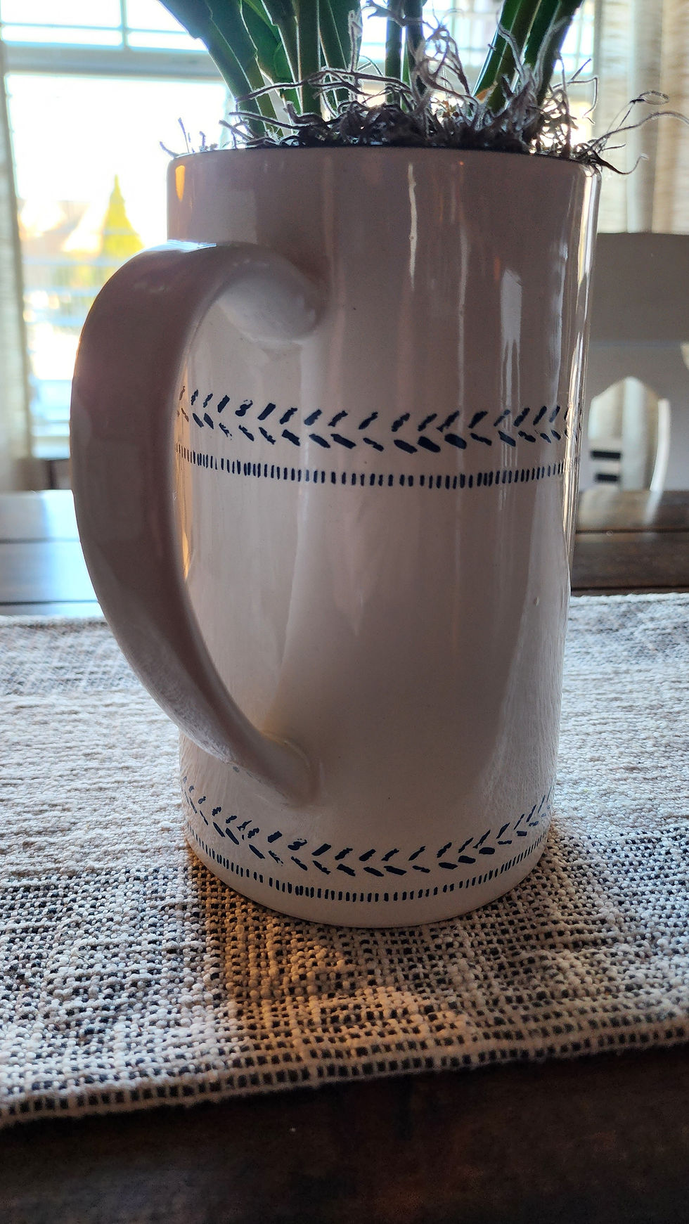 Thumbnail: Realistic tulips are perfectly displayed in a white and blue ceramic vase pitcher. 