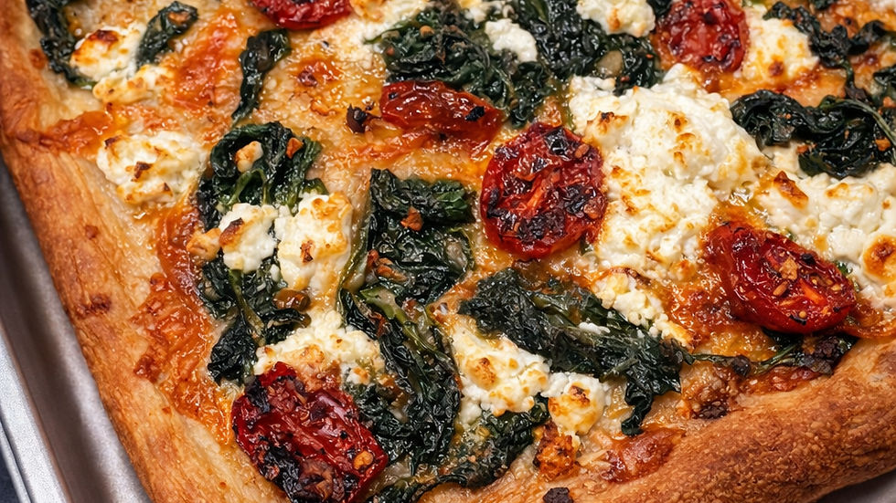 Close-up view of a freshly baked spinach and goat cheese pizza with golden crust
