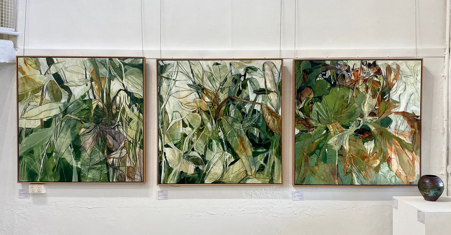 three large paintings in green