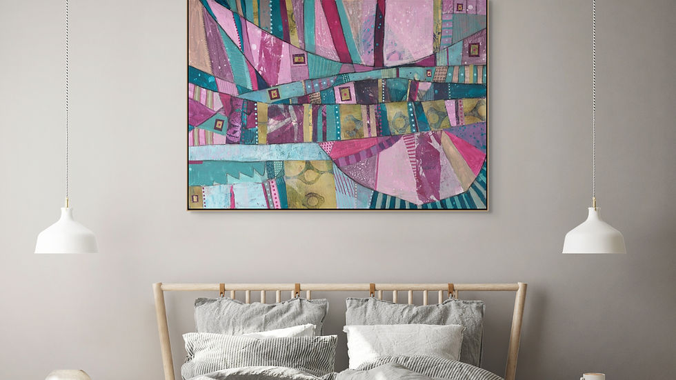 Colorful abstract painting with pink, teal, and gold hues on a wall above a bed with gray bedding. Two white pendant lights hang nearby.