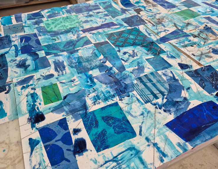 Abstract art with blue and green patches on a canvas, featuring leaf patterns and geometric shapes. The mood is creative and vibrant.