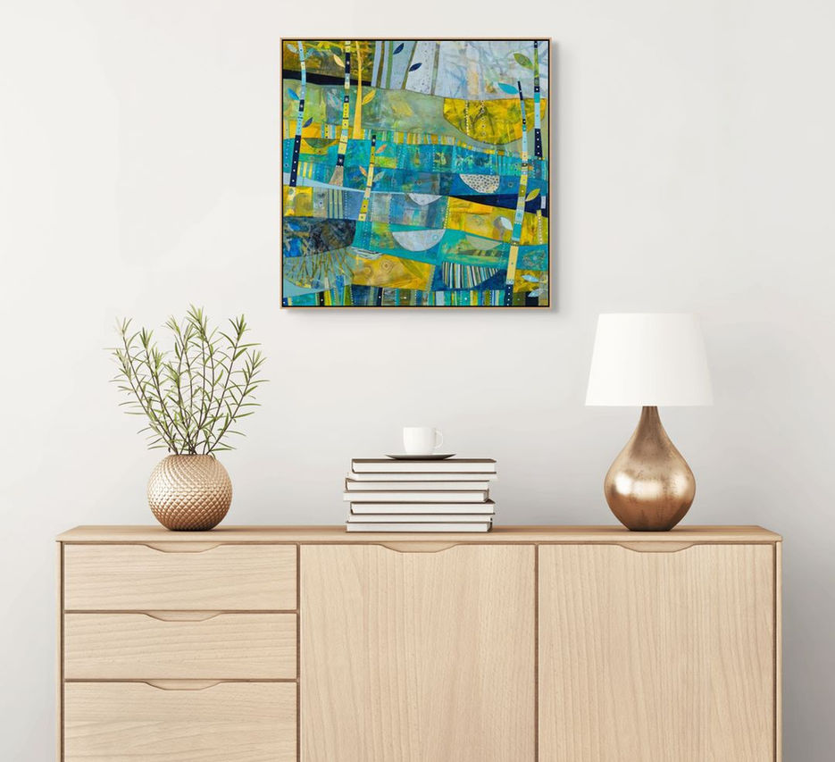 abstract landscape coastal inspired artwork in blue yellow and green framed in a room scene