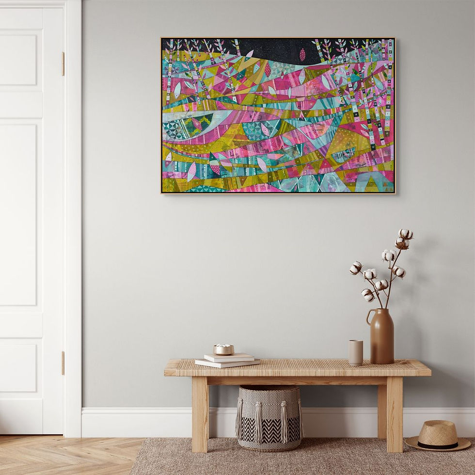 Colorful abstract painting on a gray wall above a wooden bench. Cotton flowers in a vase, books, and a straw hat add a cozy feel.