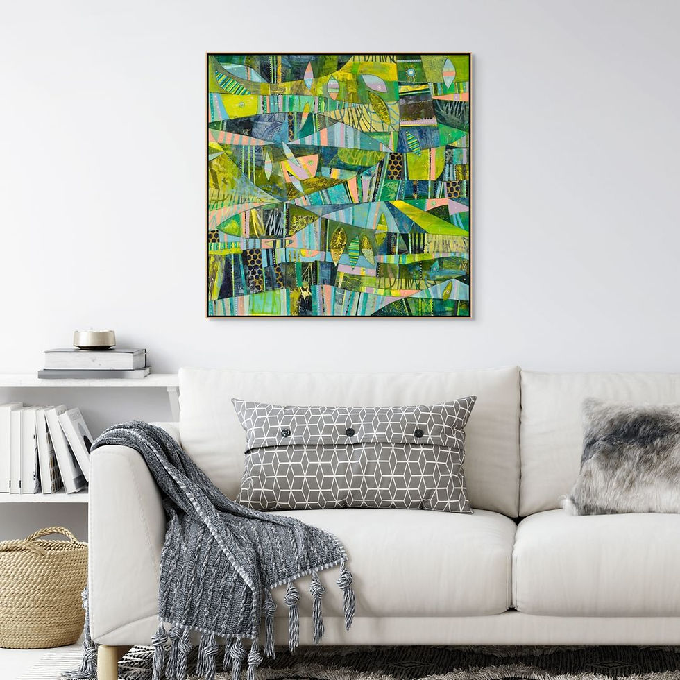 Abstract painting with green and blue patterns hangs above a white sofa with geometric and fur pillows. Books and basket on shelf nearby.