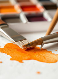 orange watercolour paint and two paintbrushes
