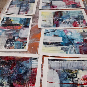 artist painting on paper on a table