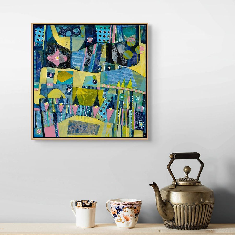 Colorful abstract painting with geometric patterns on a wall. Below, a vintage kettle and two decorative cups sit on a light wooden surface.