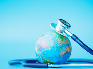 global healthcare; stethoscope wrapped around globe on blue background