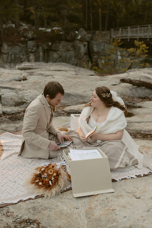 Couple enjoying a picnic on white mountains elopement day along the kancamagus highway after loon mountain elopement