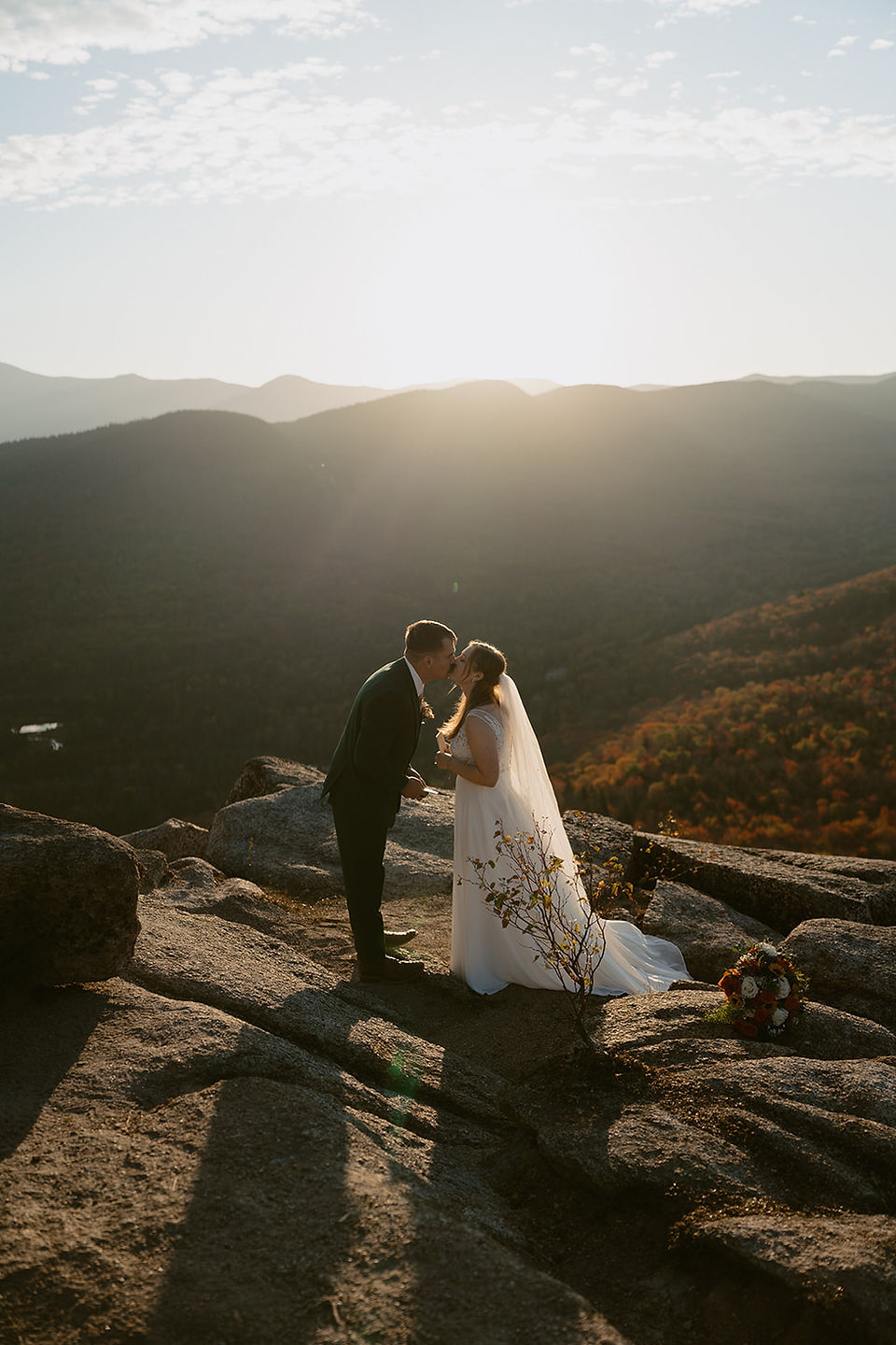White Mountains Micro Wedding with family on a mountain top at sunrise in the fall couple sharing a kiss after vows