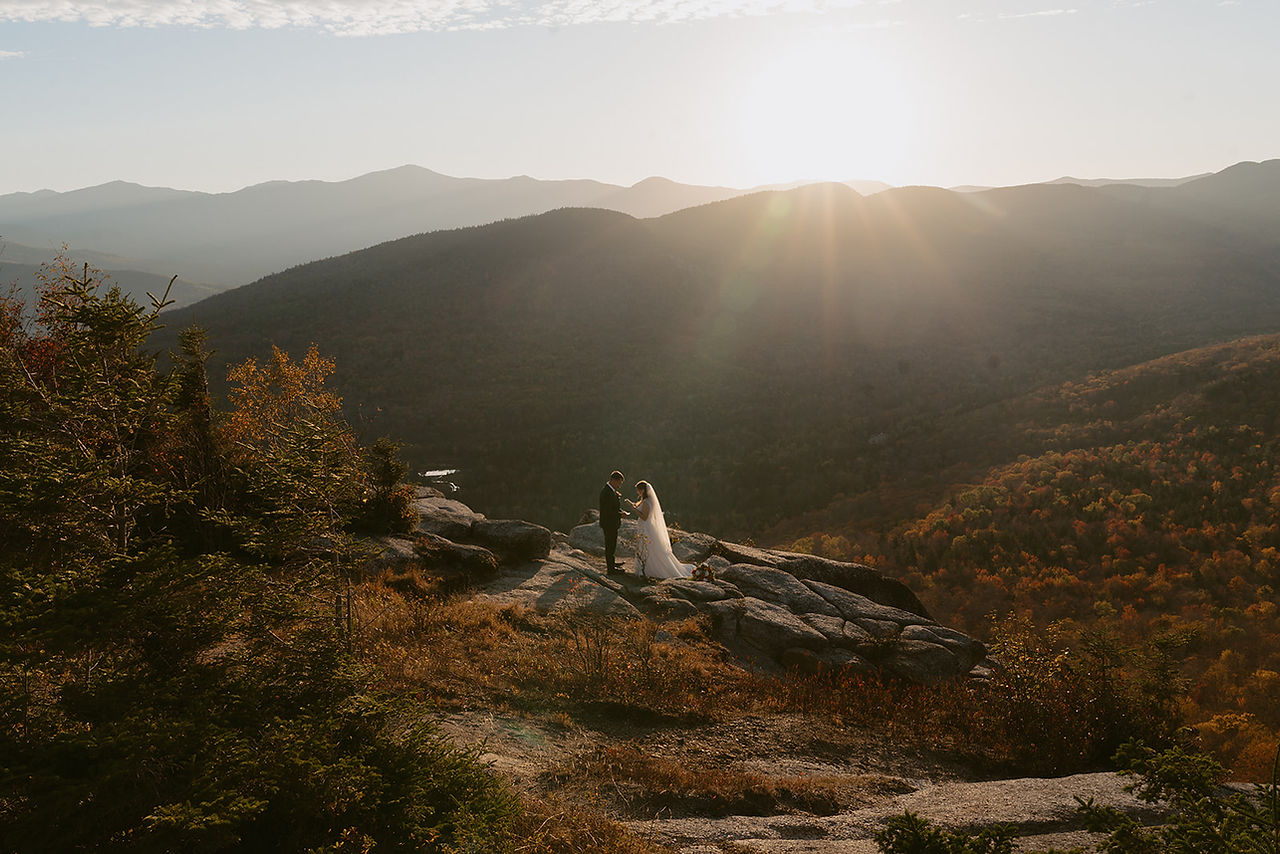 White Mountains Micro Wedding with family on a mountain top at sunrise in the fall couple doing private vows before ceremony with family