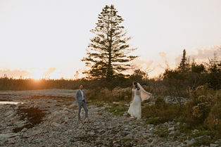 Couple exploring beach at sunset in Acadia for September Elopement day