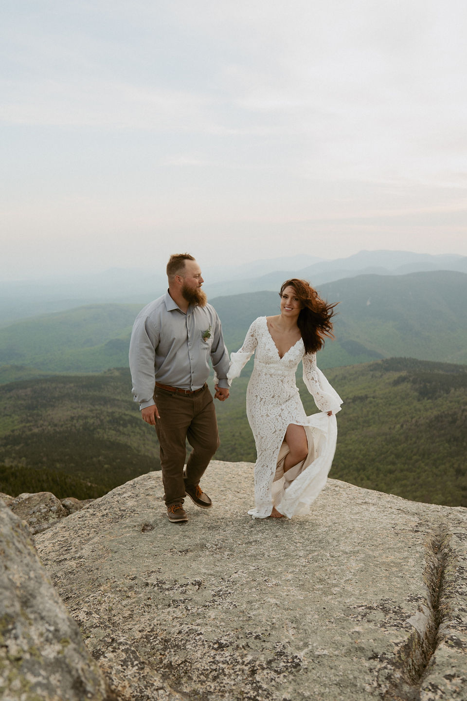 Mount Chocorua Elopement couple saying vows on mountain top with layers of mountains behind them.
