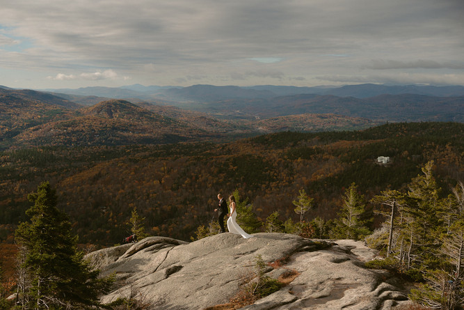 Couple on mountain top in franconia notch on elopement day enjoying sunrise.
