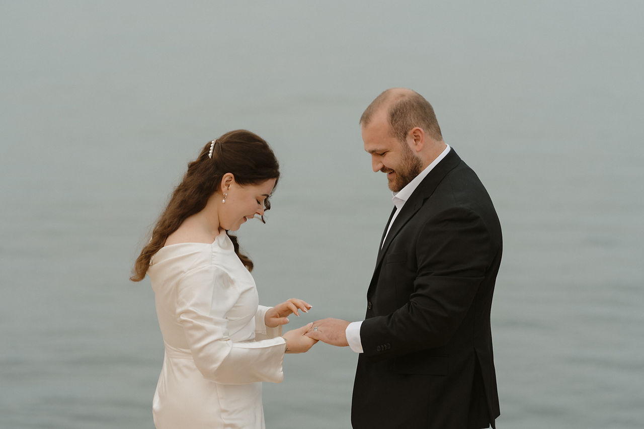 couple exchanging vows on rocky coastline in southwest harbor maine for acadia elopement