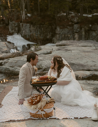 Couple enjoying a picnic on white mountains elopement day along the kancamagus highway after loon mountain elopement