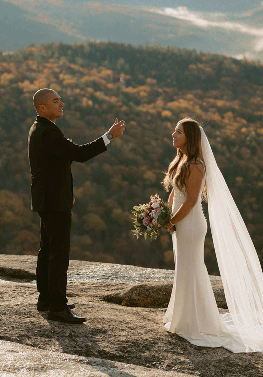 gif eloping couple flipping a coin to see who reads their vows first on mountain top in the white mountains on elopement day.