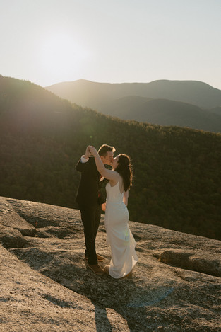 Couple exploring after ceremony on mountain top for sunrise elopement in waterville valley