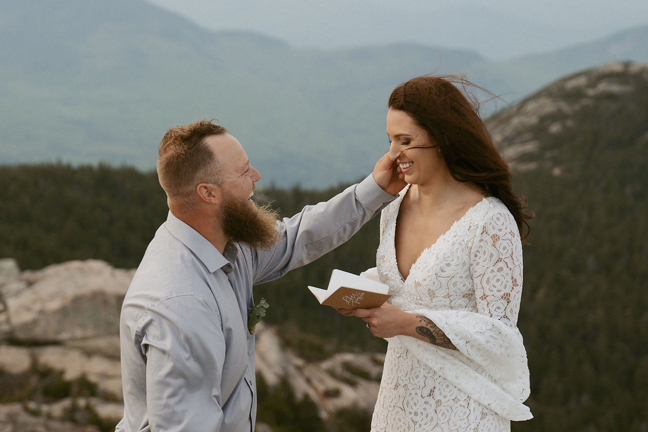 Mount Chocorua Elopement couple saying vows on mountain top with layers of mountains behind them.