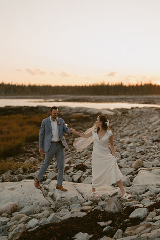 Couple exploring beach at sunset in Acadia for September Elopement day